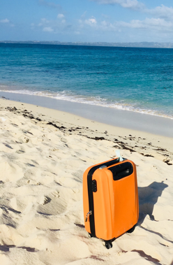 Einzelner Koffer am Strand